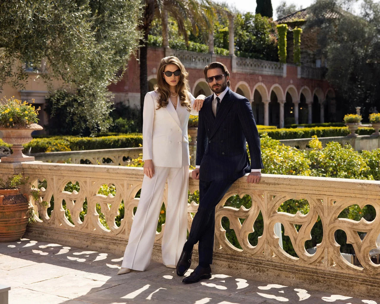 An ivory women's outfit and a navy men's suit, a photograph from the official Maison Consiglieri page